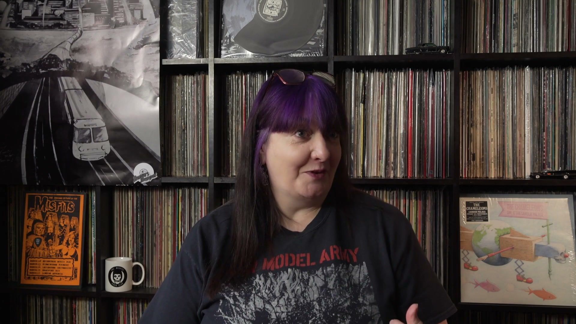Alison in front of floor-to-ceiling record shelves, smiling and looking off-camera.