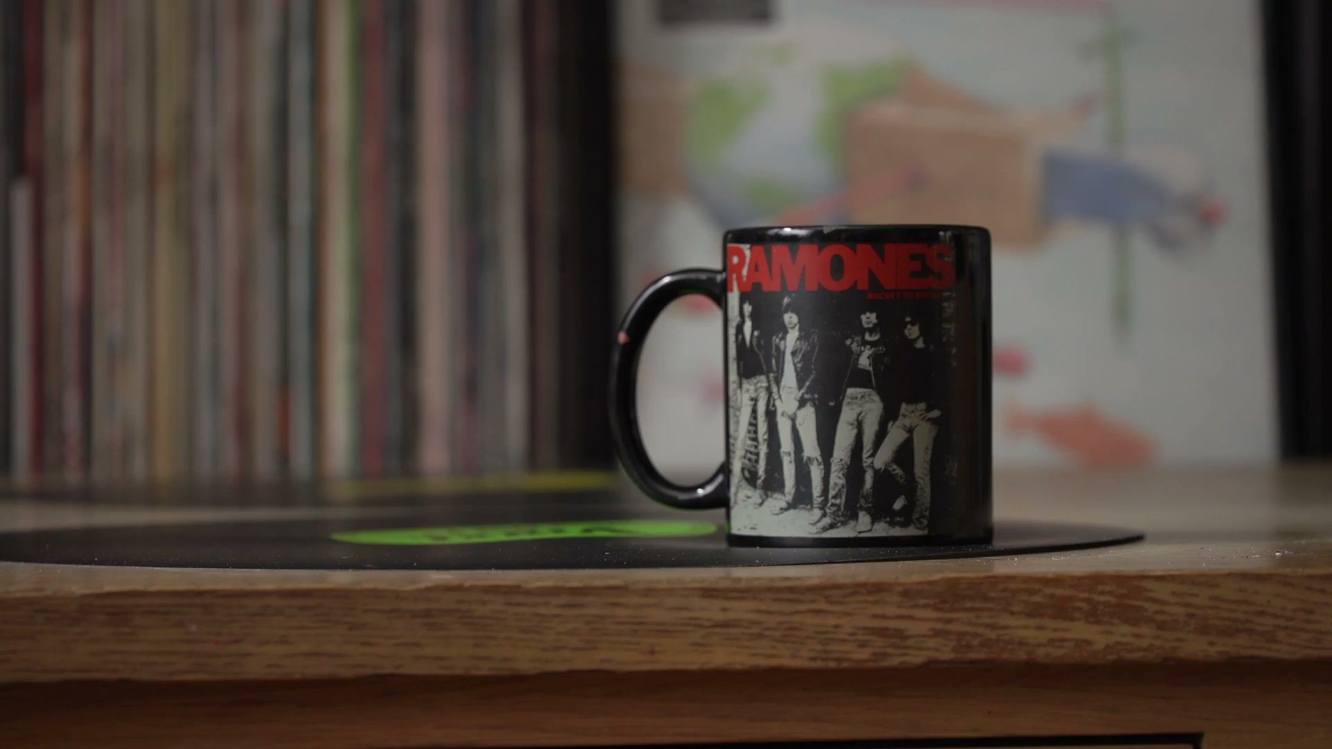 A Ramones mug on a wooden table, records out of focus behind. (opens a larger view)