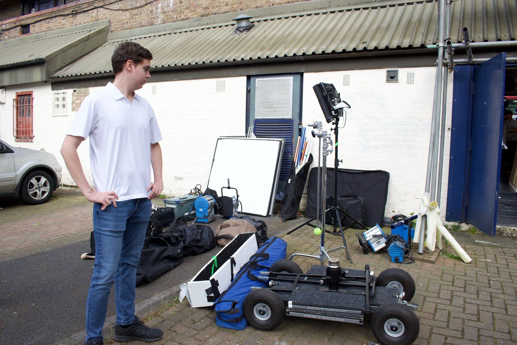 Kaan Çakır outside the studio unit during the load-in, next to the dolly, lights and stands. (opens a larger view)