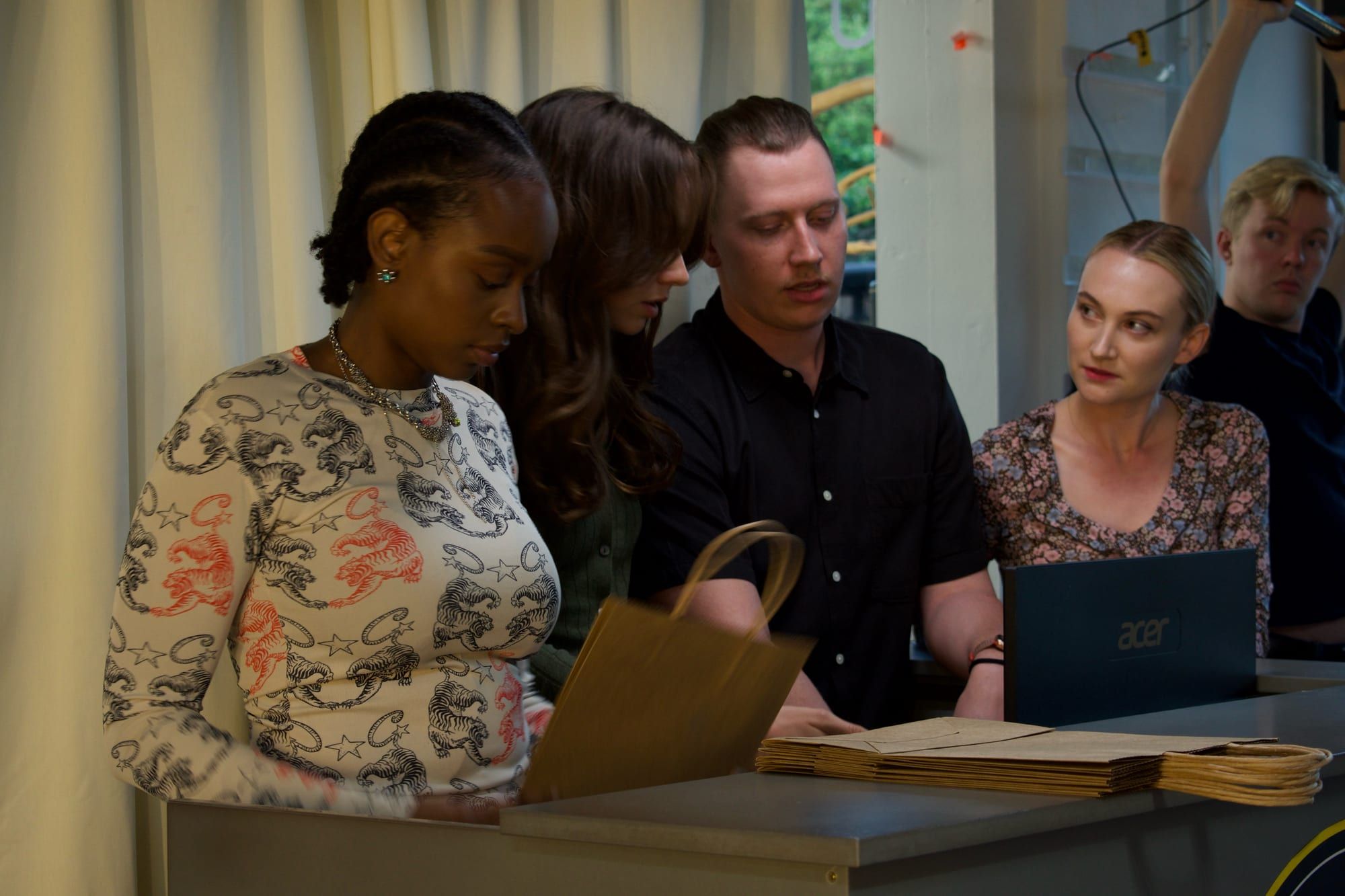 Actors and crew bent over papers and a laptop at the reception desk, going through the scene. (opens a larger view)